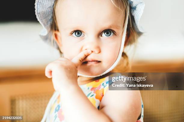 a cute little baby girl with bright blue eyes rubbing her nose - kid rubbing eyes stock pictures, royalty-free photos & images