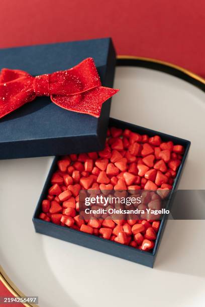 valentine's day gift box filled with red heart-shaped candies on a decorative plate - unusual shaped stock pictures, royalty-free photos & images