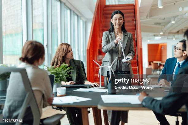 young asian businesswoman presenting renewable energy development to her colleagues in a meeting - technologie verte photos et images de collection