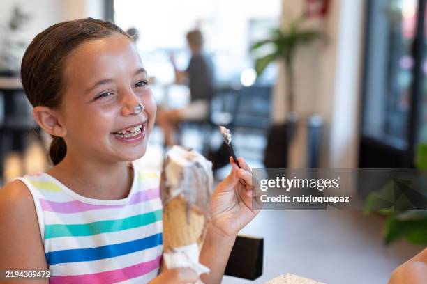 mädchen genießt ein eis in einer eisdiele - boy and girl eating ice cream stock-fotos und bilder