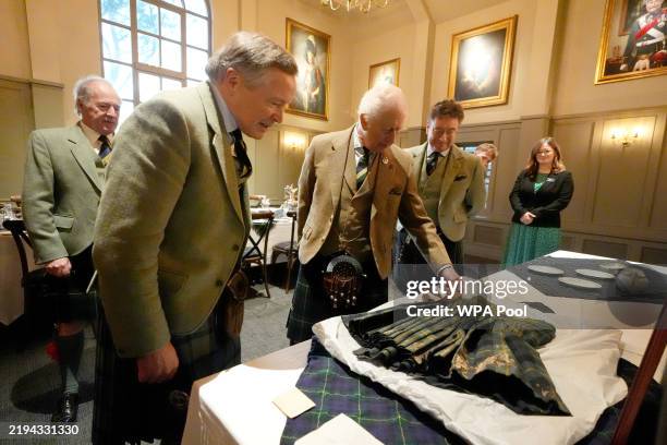 King Charles III meets Alexander 'Sandy' Manson as they view a kilt worn by Sandy's grandfather Captain Alexander Manson during a visit to the Gordon...