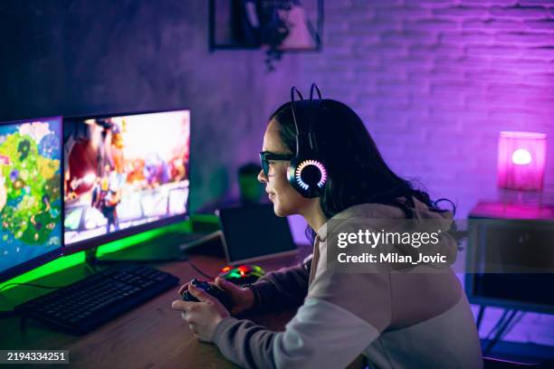 woman gamer plays online video game on joystick at home at night - games console stock pictures, royalty-free photos & images