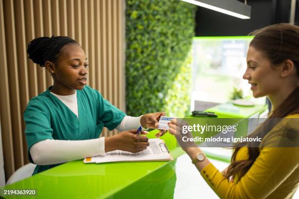 medical worker talking with patient at the clinic - medical insurance stock pictures, royalty-free photos & images