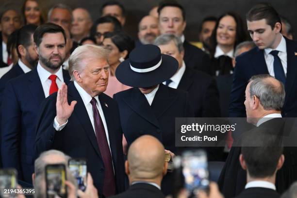 Donald Trump is sworn in as president by Supreme Court Chief Justice John Roberts as Melania Trump holds the Bible in the U.S. Capitol Rotunda on...