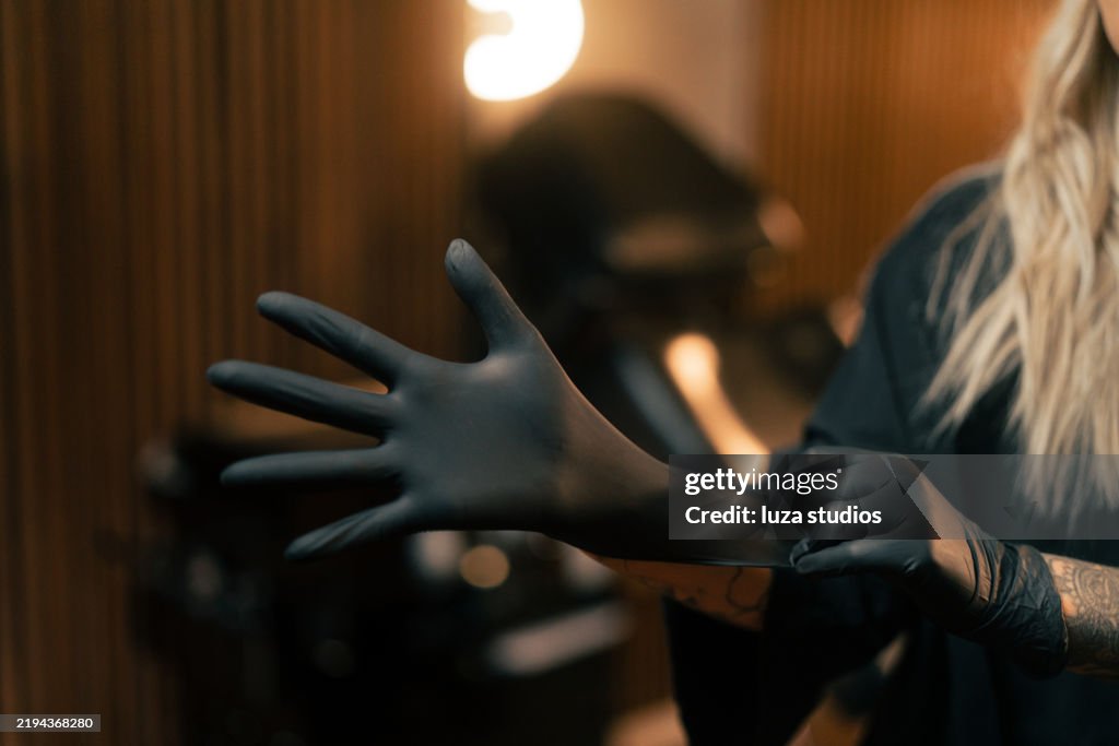 Tatuador profesional preparándose para una sesión en un estudio moderno