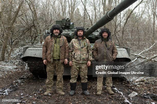 Crew members of a T-64 tank of the AFU's 157th Separate Mechanized Brigade, pose for the camera next to a T-64 tank that keeps defense in the...