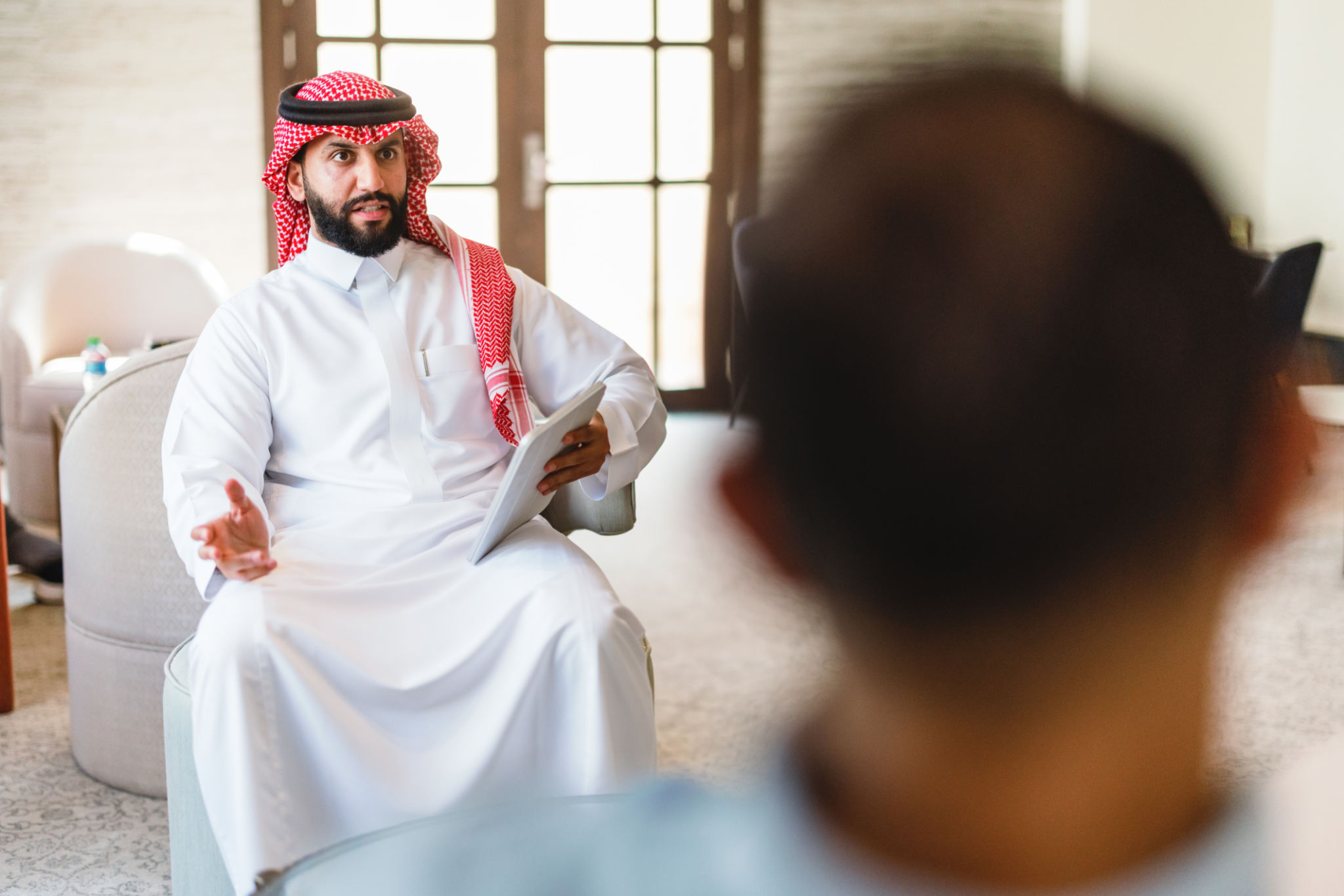 Confident Arabic Businessmen Engaged in Hotel Lobby Meeting Confident Arabic Businessmen Engaged in Hotel Lobby Meeting