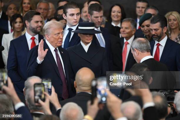 Donald Trump is sworn in as president by Supreme Court Chief Justice John Roberts on a Bible held by Melania Trump in the U.S. Capitol Rotunda on...