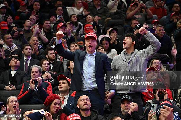 Supporters of US President Donald Trump react as they watch a screen while Donald Trump is sworn in as the 47th president of the United States inside...