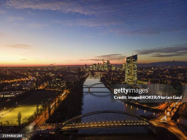 the lights in the offices of the european central bank (ecb) and in the skyscrapers of frankfurt's banking skyline glow in the evening shortly after sunset. (aerial view with a drone), frankfurt am main, osthafen, hesse, germany, europe - osthafen berlin stock pictures, royalty-free photos & images