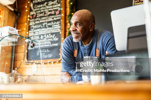 Portrait of senior male cafe owner at front counter Portrait of senior male cafe owner at front counter