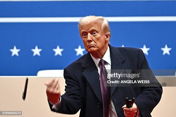 President Donald Trump throws sharpies to the crowd after signing executive orders during the inaugural parade inside Capital One Arena, in...