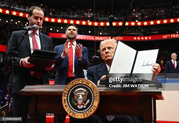 President Donald Trump holds an executive order announcing the US withdrawal from the Paris Agreement, he just signed during the inaugural parade...