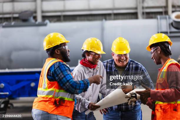 multiracial group of engineers meeting on factory floor - construction workers reading blueprints stock pictures, royalty-free photos & images