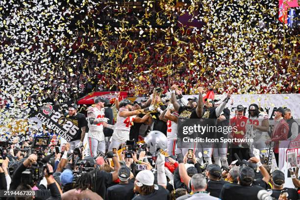 Ohio State players celebrate with the winning trophy following the conclusion of the the Ohio State Buckeyes versus Notre Dame Fighting Irish College...