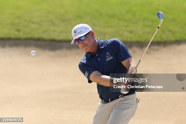 Justin Leonard of the United States chips from the bunker onto the eighth green during the second round of the Mitsubishi Electric Championship at...