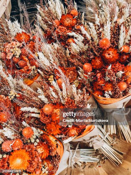 boho bouquets of beautiful decorative red dried flowers herbs wrapped in craft paper. - fall flowers home stock pictures, royalty-free photos & images