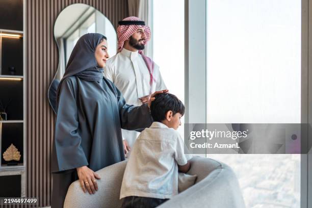 joyful arabic family admiring riyadh skyline from modern home - saudi arabia skyline stock pictures, royalty-free photos & images