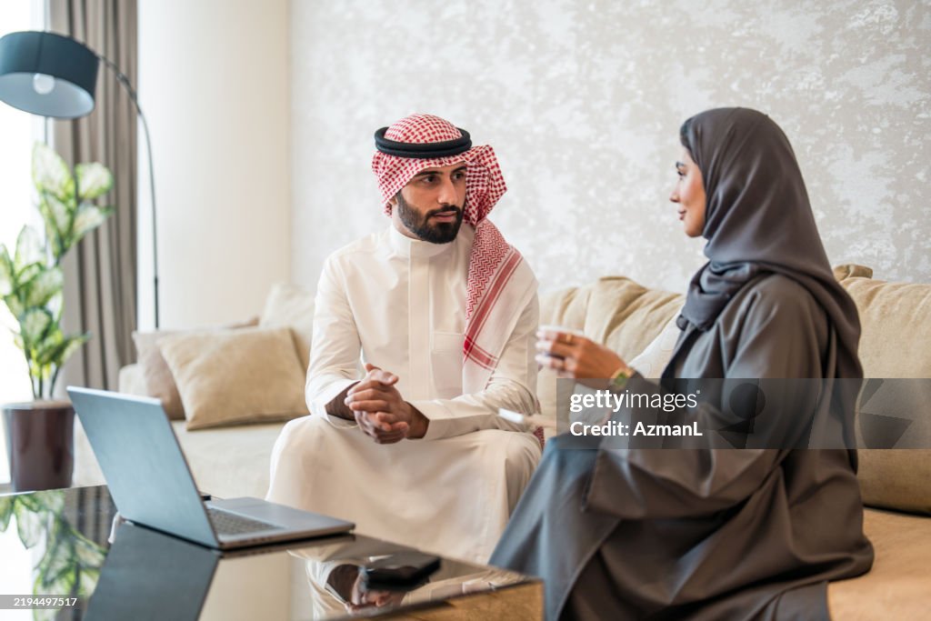 Engaged Arabic Business Executives Collaborating in Modern Hotel Lobby