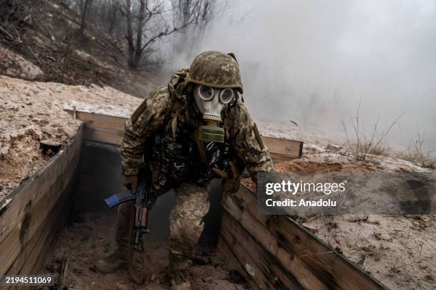 Ukrainian soldiers from the 28th Infantry Brigade take part in tactical training exercises wearing gas masks in a rural area of Ukraine as the war...