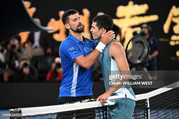 Serbia's Novak Djokovic embraces Spain's Carlos Alcaraz after their men's singles quarterfinal match on day ten of the Australian Open tennis...