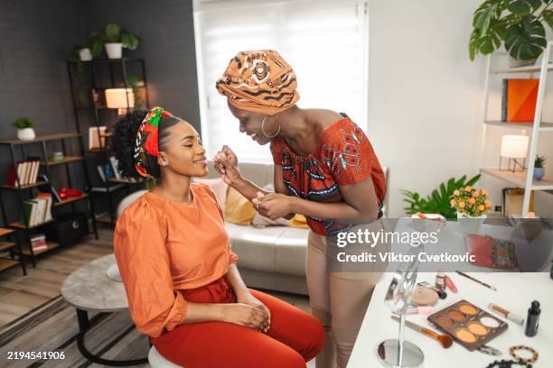 make-up artist applying lipstick on client's lips at home - makeup artist stock pictures, royalty-free photos & images