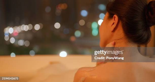 asian female enjoy soakbathe night - pat on the back stockfoto's en -beelden