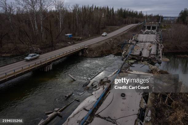 Cars pass over a new bridge built alongside one that was destroyed during the Russian occupation, on January 21, 2025 in Izyum, Ukraine. Ukraine...