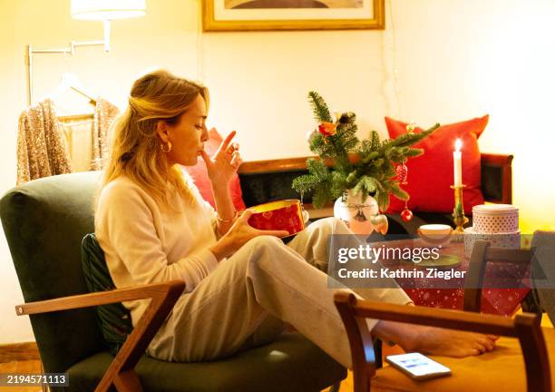 woman relaxing at home, eating christmas cookies - me time stock pictures, royalty-free photos & images