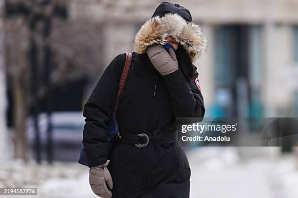 Woman covering her face with gloves walks on the street in Toronto, Canada as it is expected to be the coldest day of the winter on January 21, 2025....