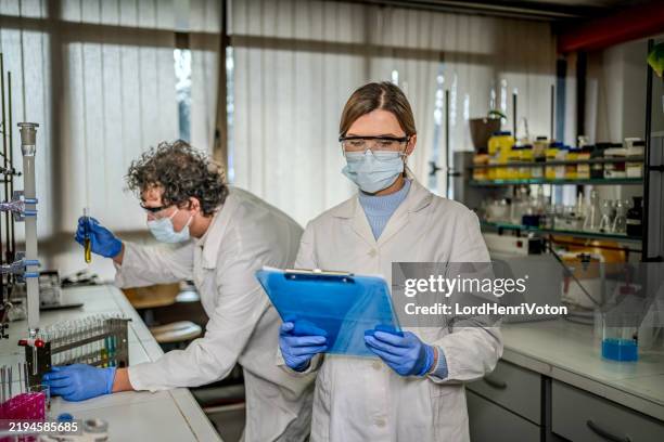 woman reading some test results while working in the laboratory - reagent stock pictures, royalty-free photos & images