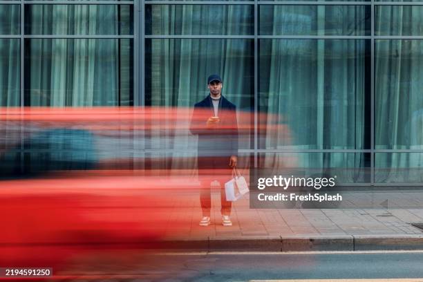 urban scene of man in motion with a passing red vehicle - high contrast lifestyle stock pictures, royalty-free photos & images
