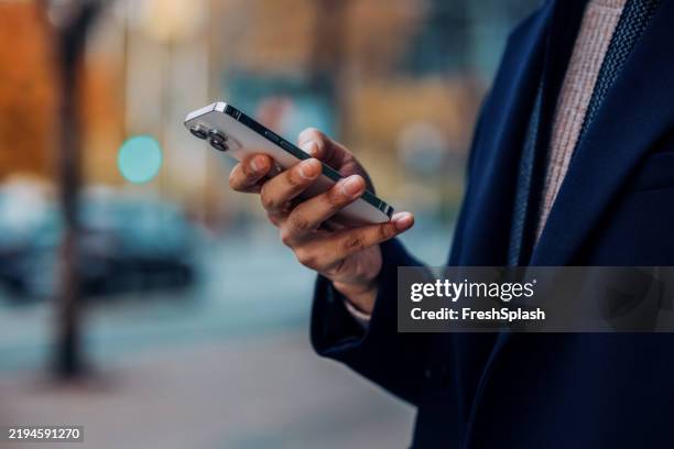 close-up of a person using a smartphone outdoors in autumn - unrecognizable person stock pictures, royalty-free photos & images