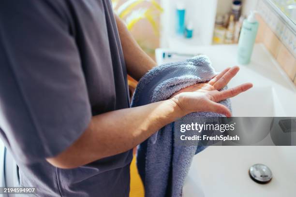 persona secándose las manos mojadas con una toalla azul en un baño - toalla fotografías e imágenes de stock