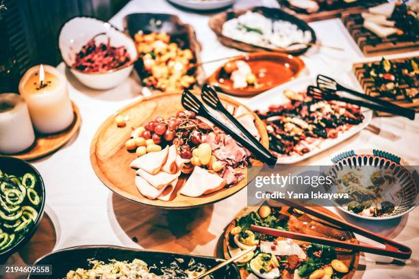wide assortment of food dishes displayed on a beautifully set table - pinça utensílio de servir - fotografias e filmes do acervo