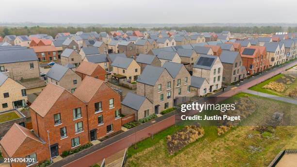 a drone/aerial view of newly built houses in the uk. some of the roofs have solar panels - cambridge stock pictures, royalty-free photos & images