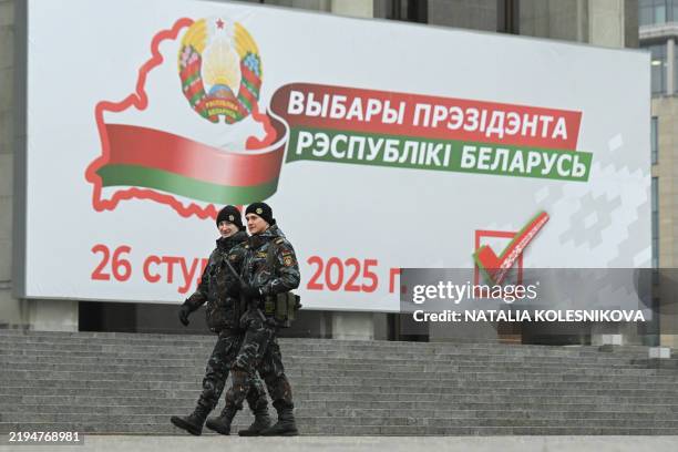 Belarusian riot police patrols in front of the Palace of the Republic decorated with a banner informing of Belarus' presidential election in the...