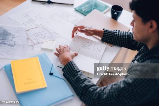architect reviewing blueprints and notes while studying at a desk - mind map stock pictures, royalty-free photos & images