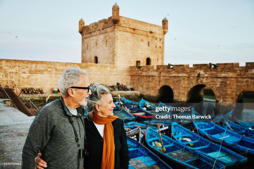 Medium shot embracing senior couple exploring the port Essaouira