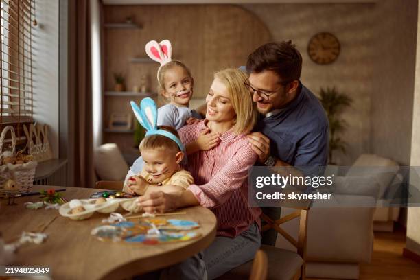 feliz familia divirtiéndose durante la celebración de pascua en casa. - pascua fotografías e imágenes de stock