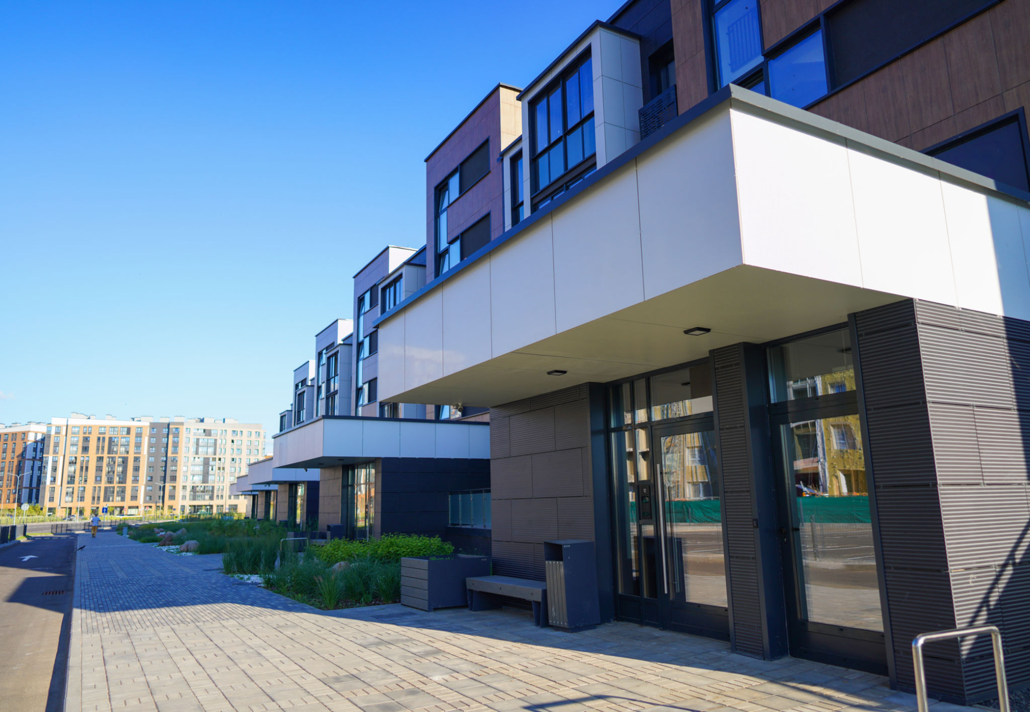 Modern complex building. Street with road and sidewalk. Modern complex building. Street with road and sidewalk.