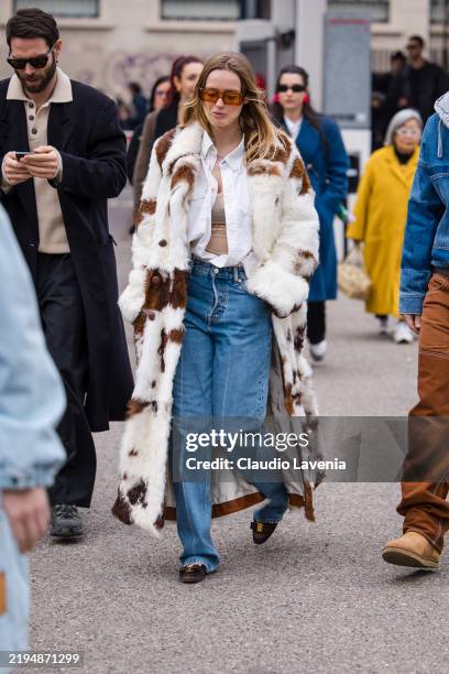 Guest wears white shirt, blue jeans, cow print fur coat, brown Ferragamo shoes, outside JordanLuca, during the Milan Fashion Week Menswear...