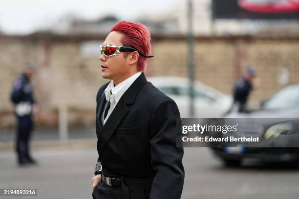 Guest wears Gentle Monster Tekken sunglasses, white buttoned up long sleeve shirt, black tie, black oversized blazer jacket, black leather belt,...