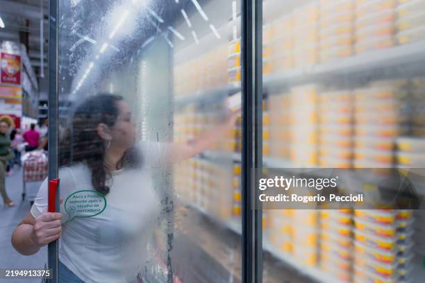 woman stands with a cart in the freezer and dairy department chooses goods and makes purchases. - frys bildbanksfoton och bilder