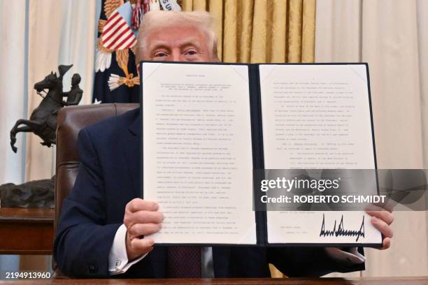 President Donald Trump holds the executive order he signed to declassify the files of slained former President John F. Kennedy, former Attorney...