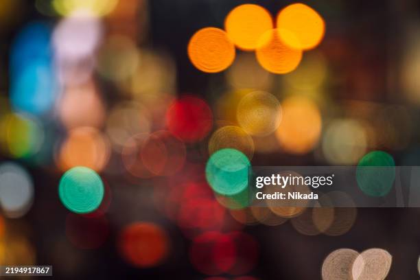 les lumières de la ville la nuit avec une circulation floue en mouvement - lumière ambiante photos et images de collection