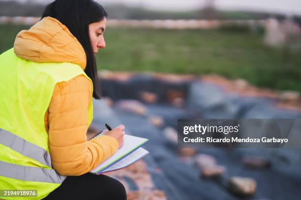 archaeologist taking notes at an excavation site - archeoloog stockfoto's en -beelden