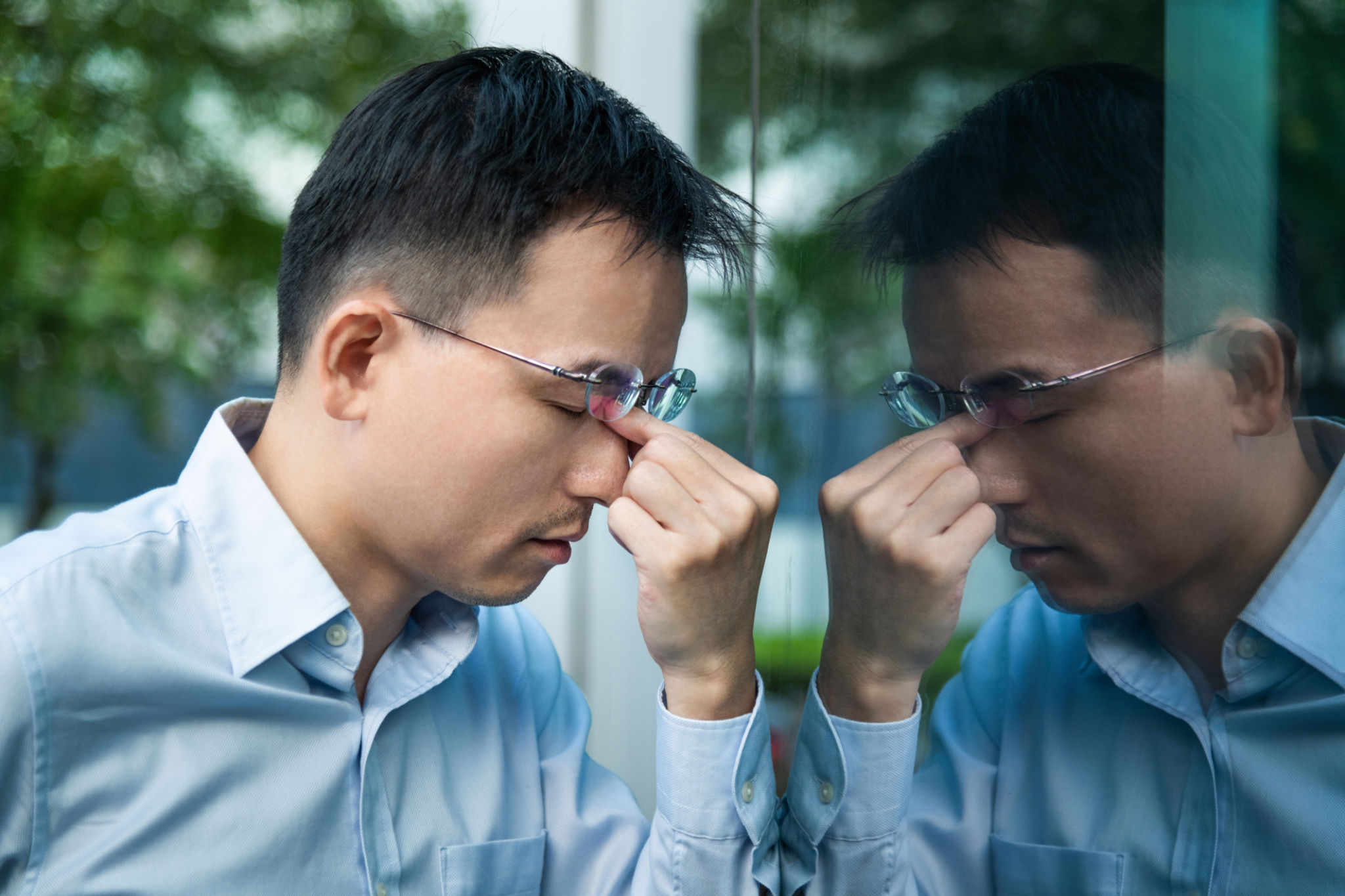 Frustrated businessman leaning at the glass wall Frustrated businessman leaning at the glass wall