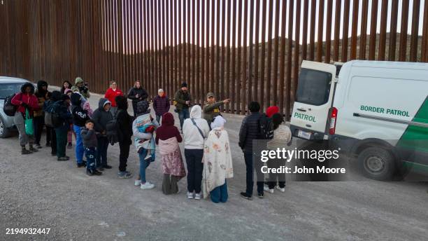 Immigrants wait to be transported by U.S. Border Patrol agents after crossing the U.S.-Mexico border on January 20, 2025 near Sasabe, Arizona....