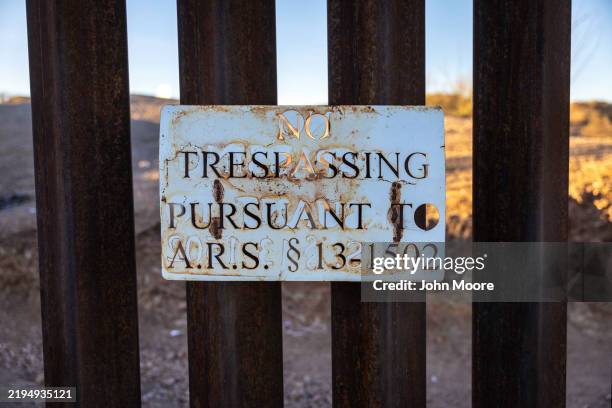 No trespassing sign hangs from the U.S.-Mexico border fence on January 20, 2025 near Sasabe, Arizona. Nightly, immigrants have passed through a gap...
